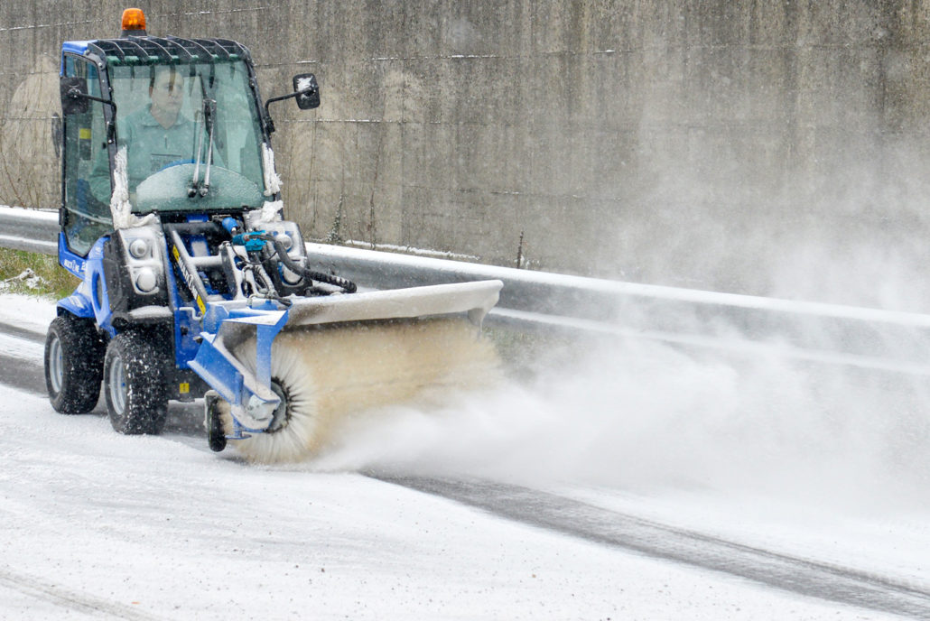 MultiOne mini loader 2 series with rotary broom cleaning a snowy street