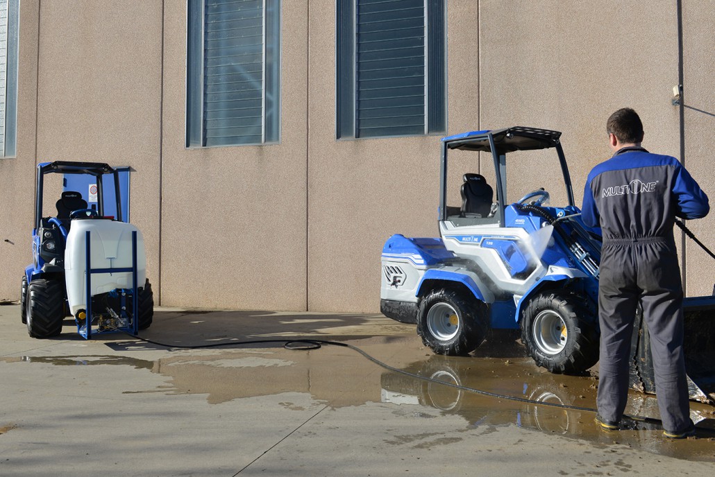 man using a high pressure washer to clean on concrete