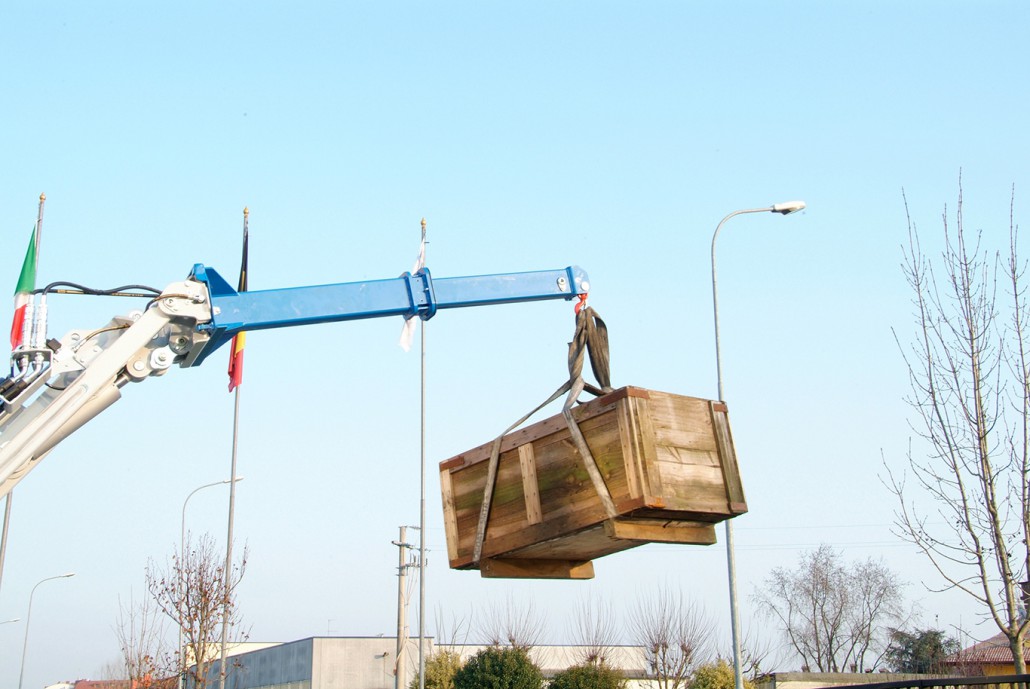 detail of a jib crane lifting a big wooden box