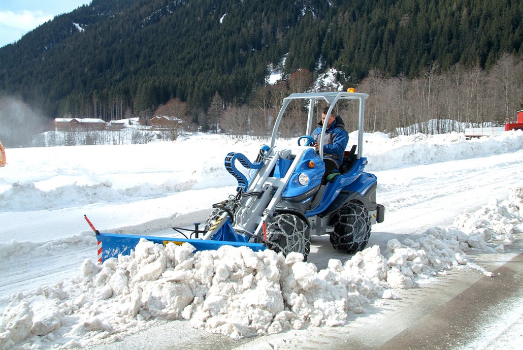 snow blade moving the snow from a mountain street